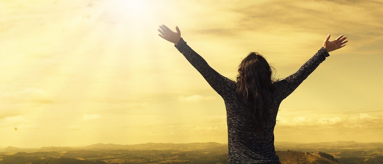 How to see the divine in absolutely everything - a woman stretching her arms out wide to represent a workshop by Gill Harbach